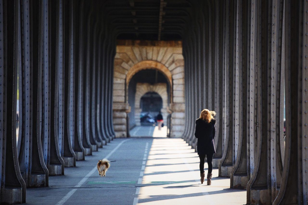 Woman with dog walking in corridor