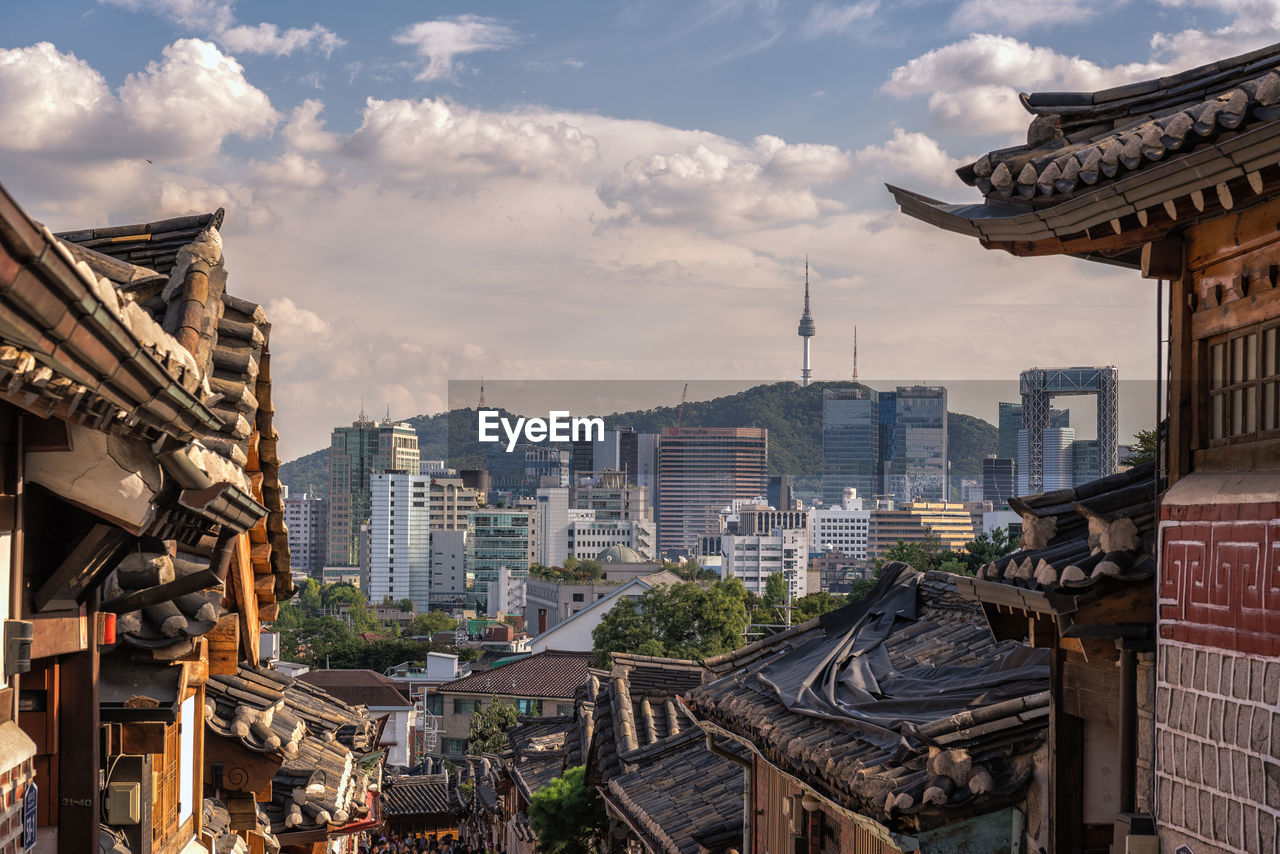 View of cityscape against cloudy sky
