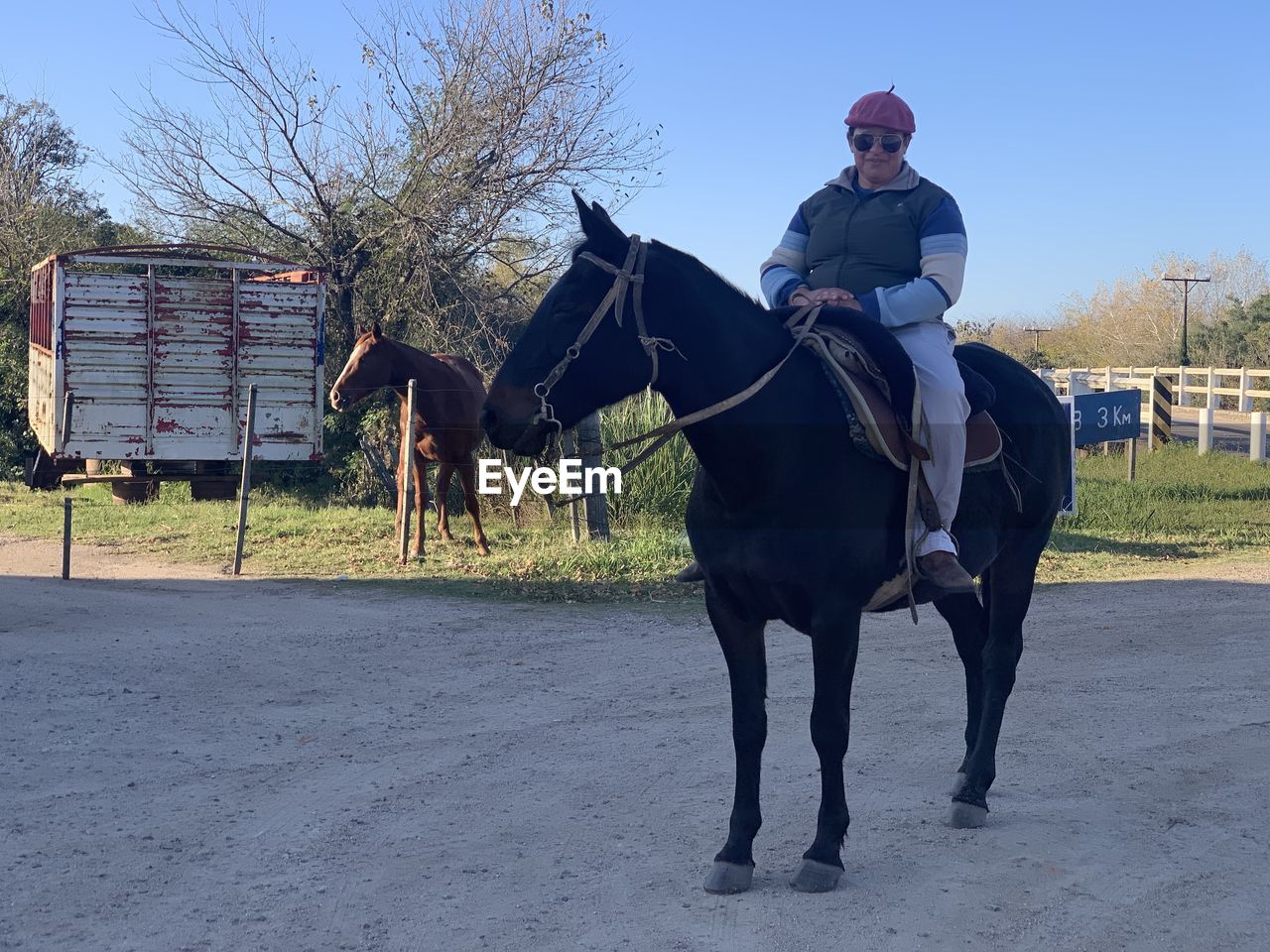 MAN RIDING HORSES AT RANCH