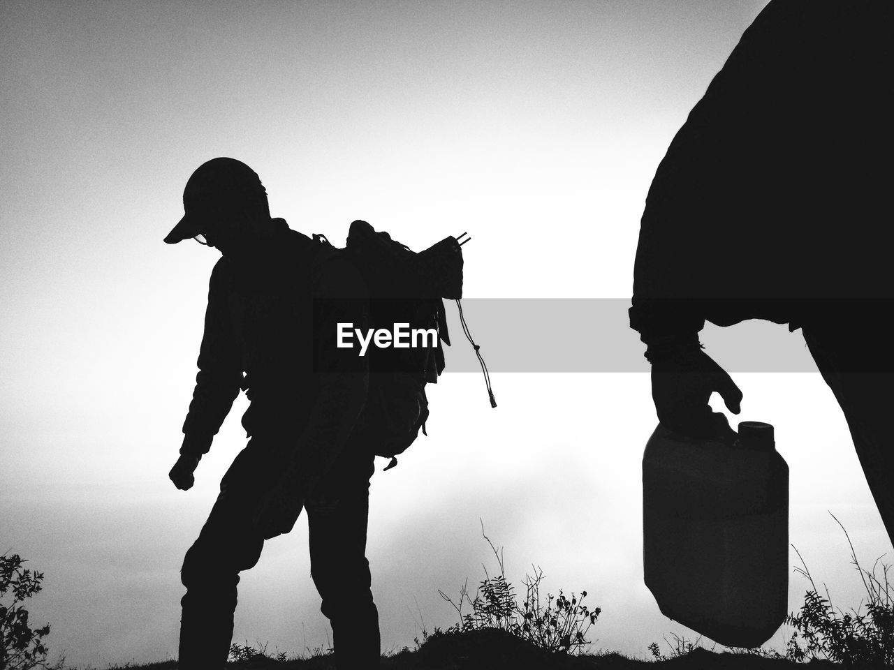 Silhouette man walking on land against sky