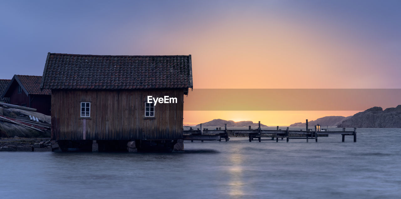 Scenic view of sea and buildings against sky during sunset