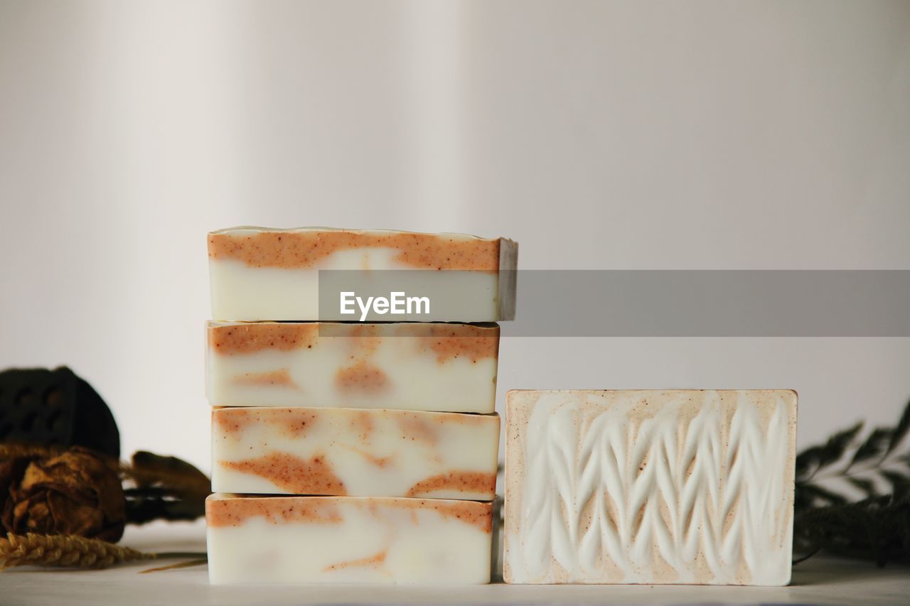 Close-up of soaps stacked against white background