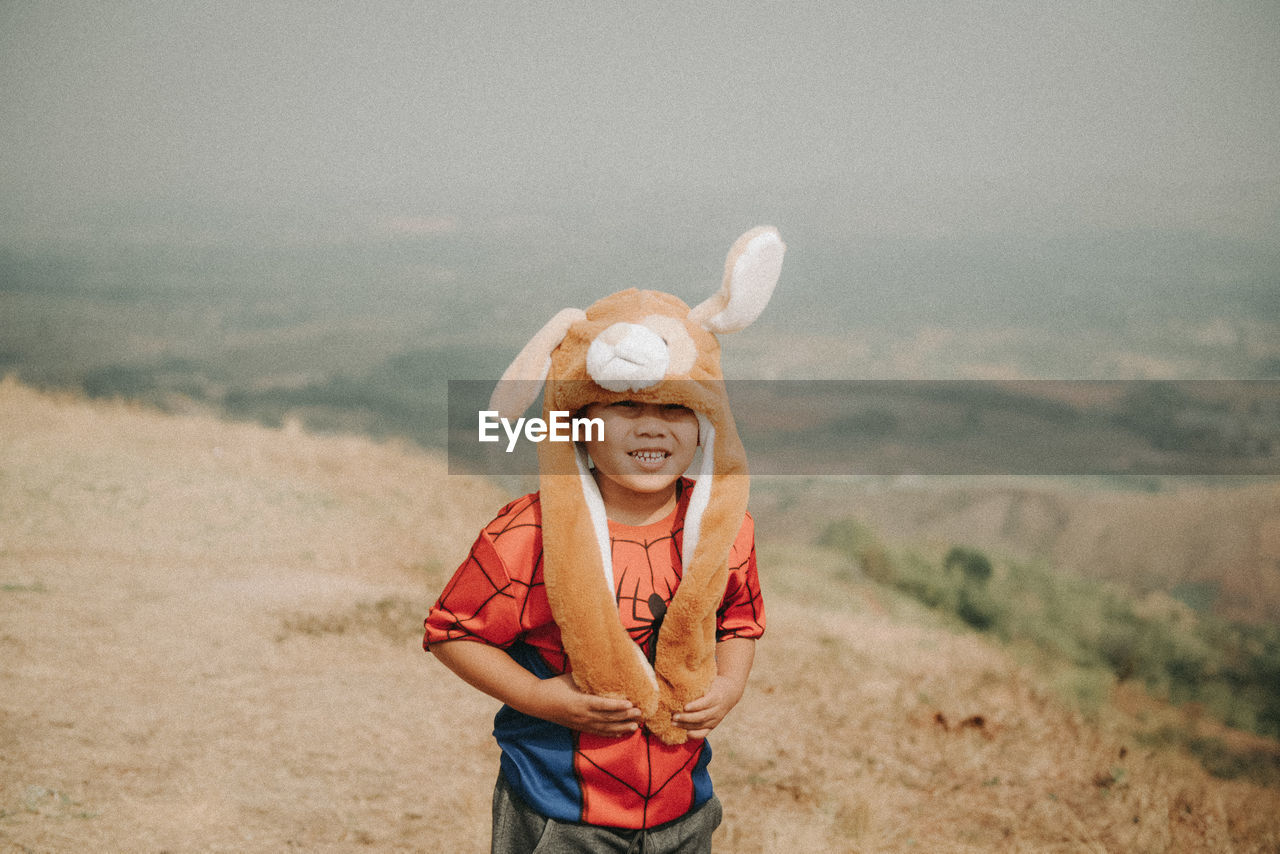 Young man wearing hat standing on land