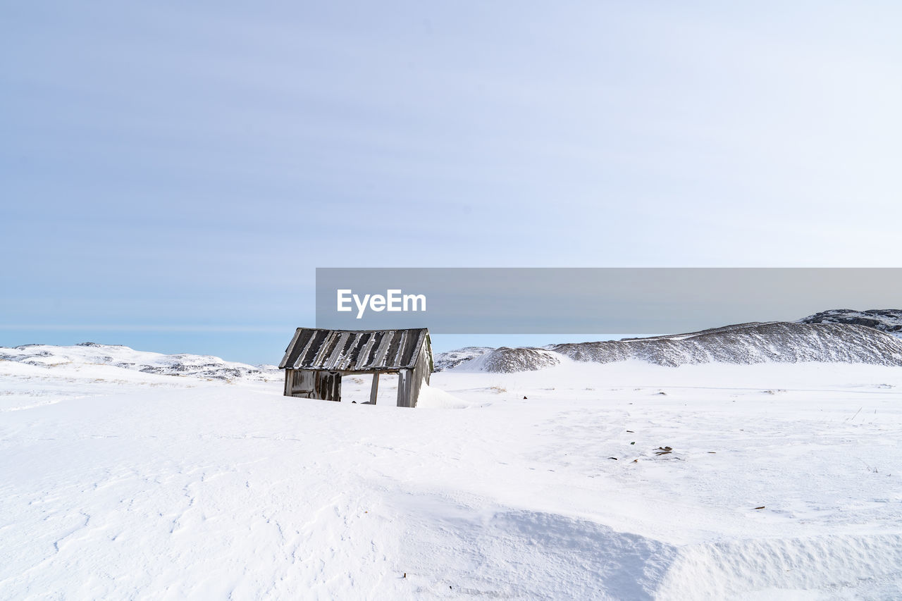 Snow covered land against sky