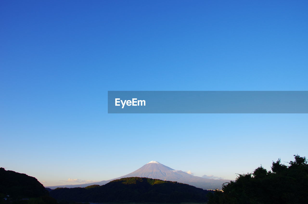 Scenic view of mountains against clear blue sky