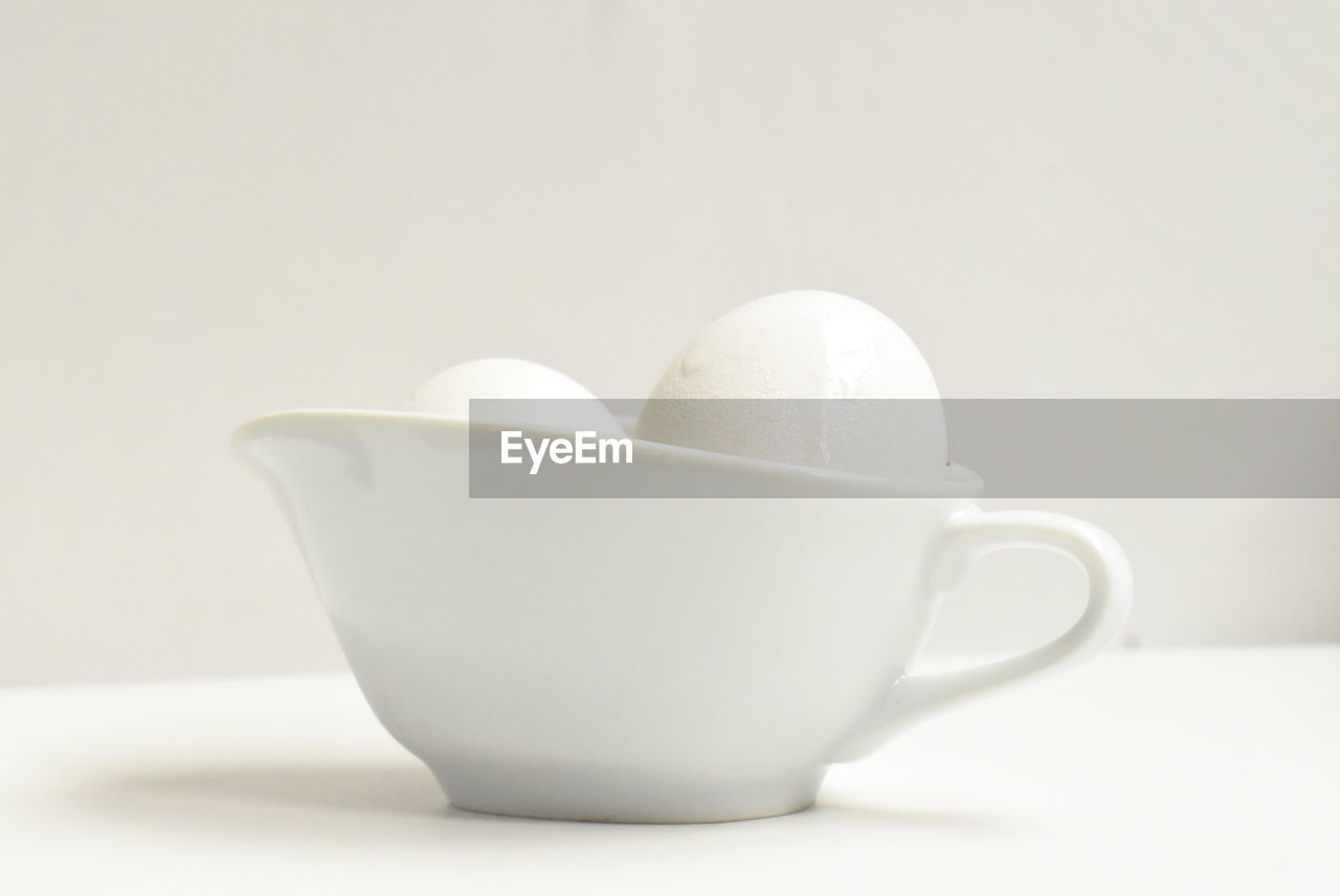 CLOSE-UP OF COFFEE CUP ON WHITE TABLE