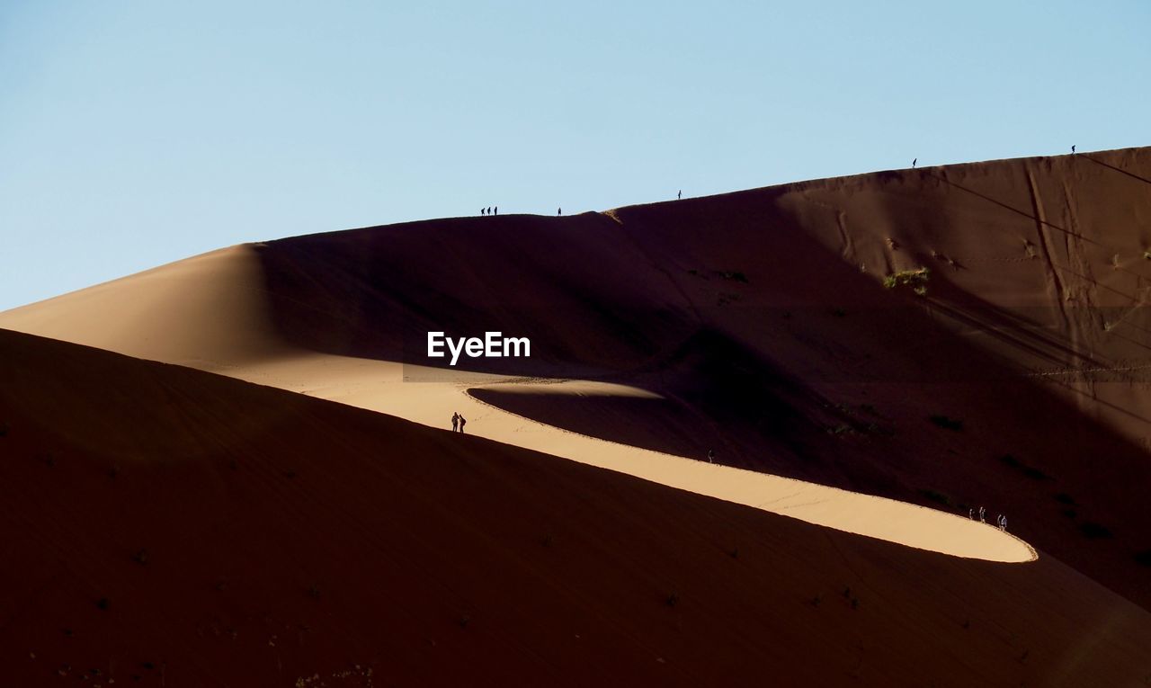 Low angle view of sane dune in namib desert against blue sky in the morning light