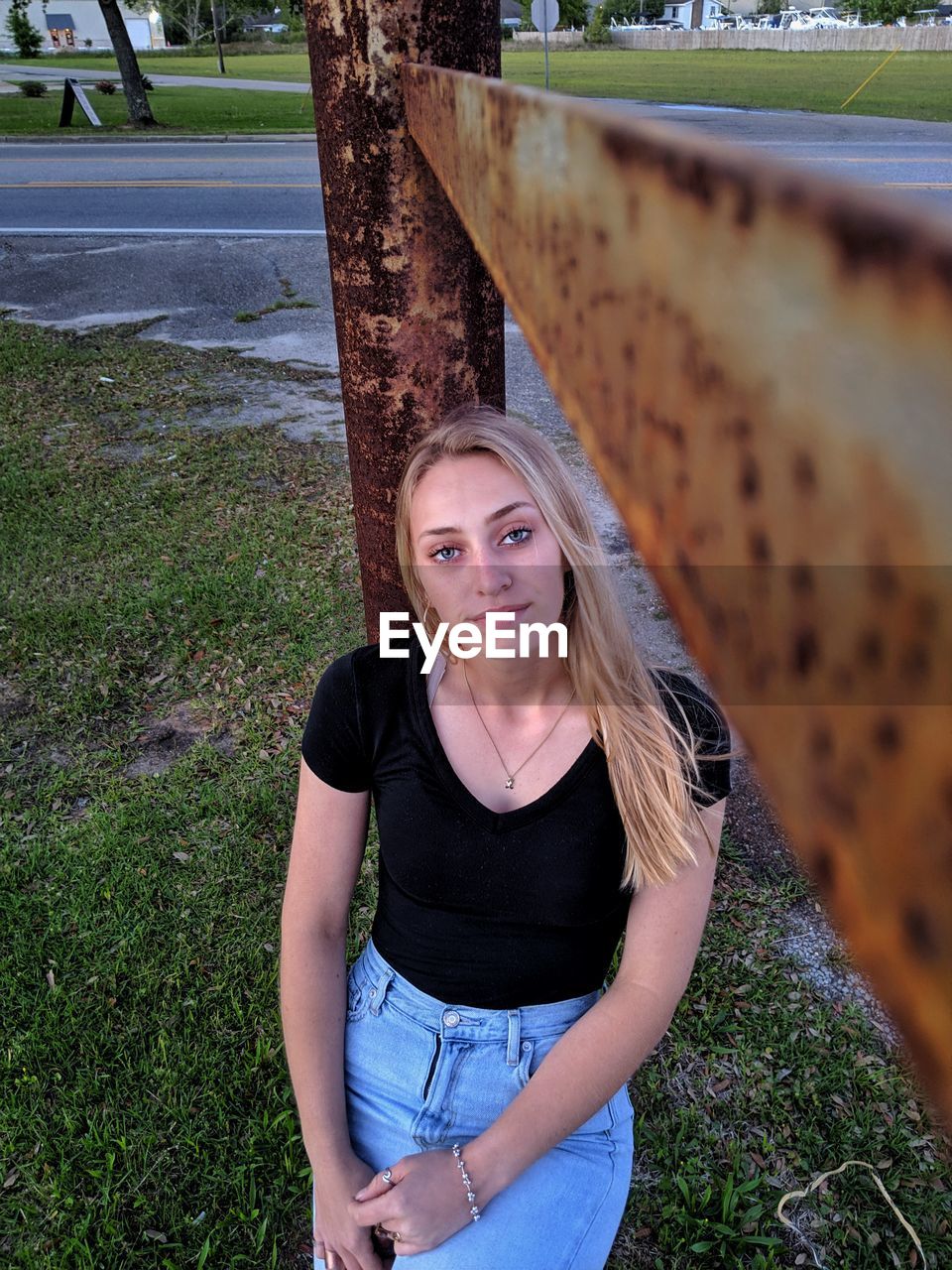 PORTRAIT OF BEAUTIFUL YOUNG WOMAN STANDING BY TREE