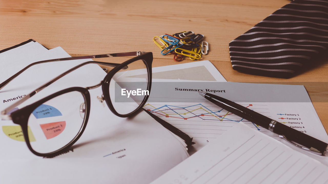 HIGH ANGLE VIEW OF EYEGLASSES ON BOOK