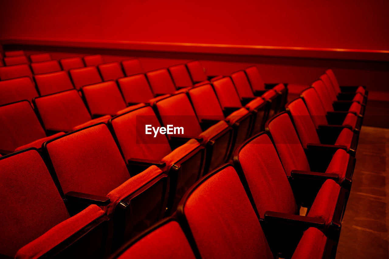 Bright red auditorium with rows of empty red cloth covered seats