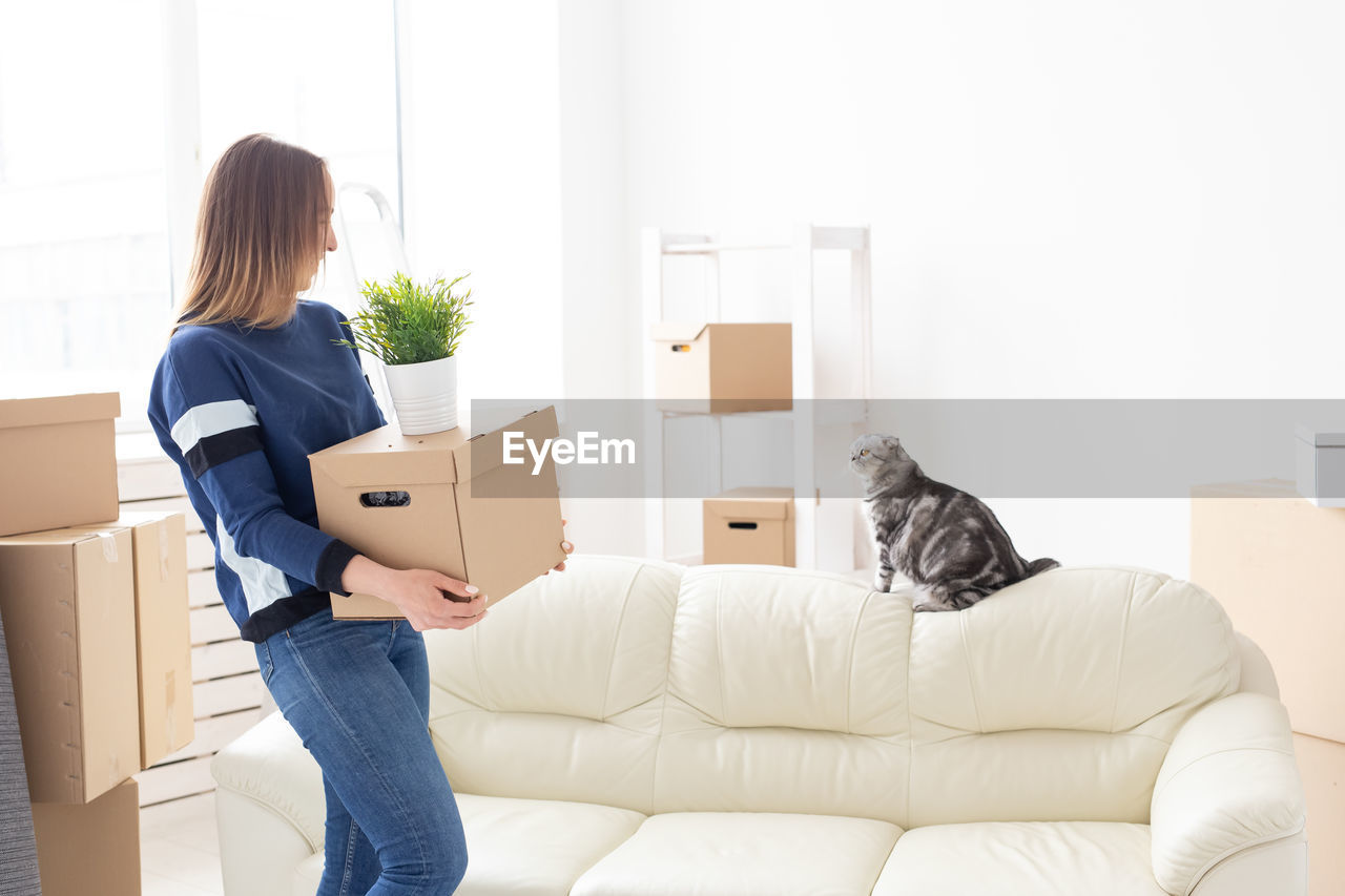 Woman carrying boxes at home