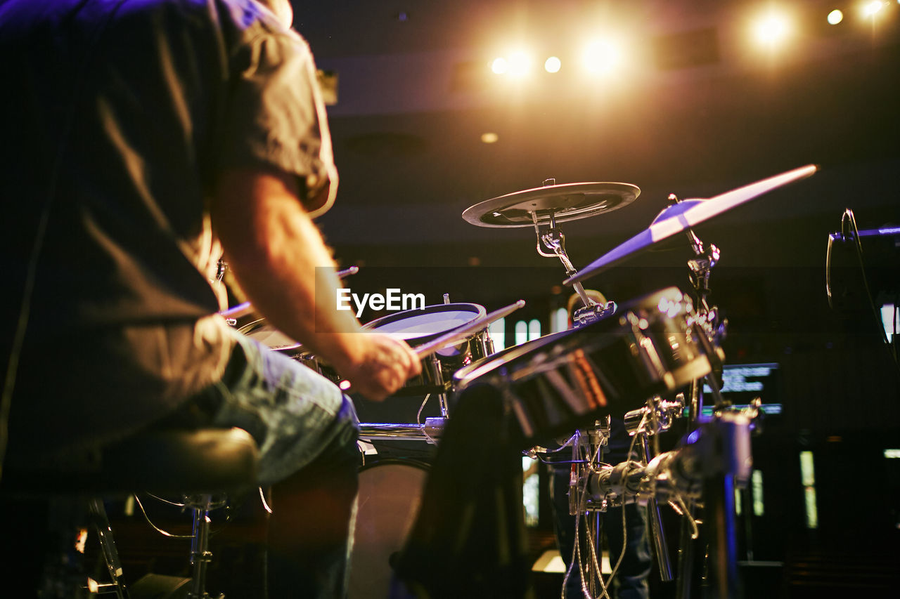 Midsection of man playing drum