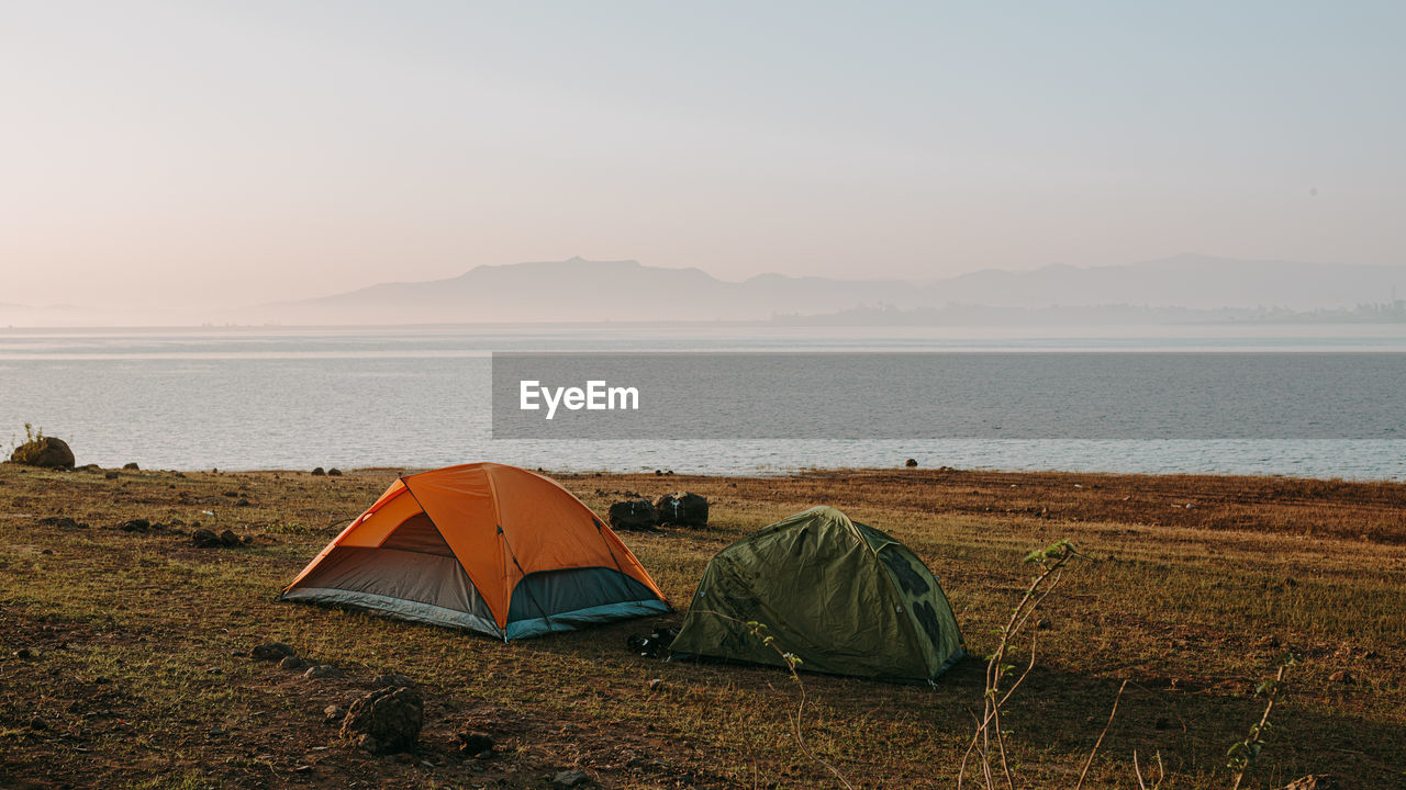 Tent on beach by sea against sky