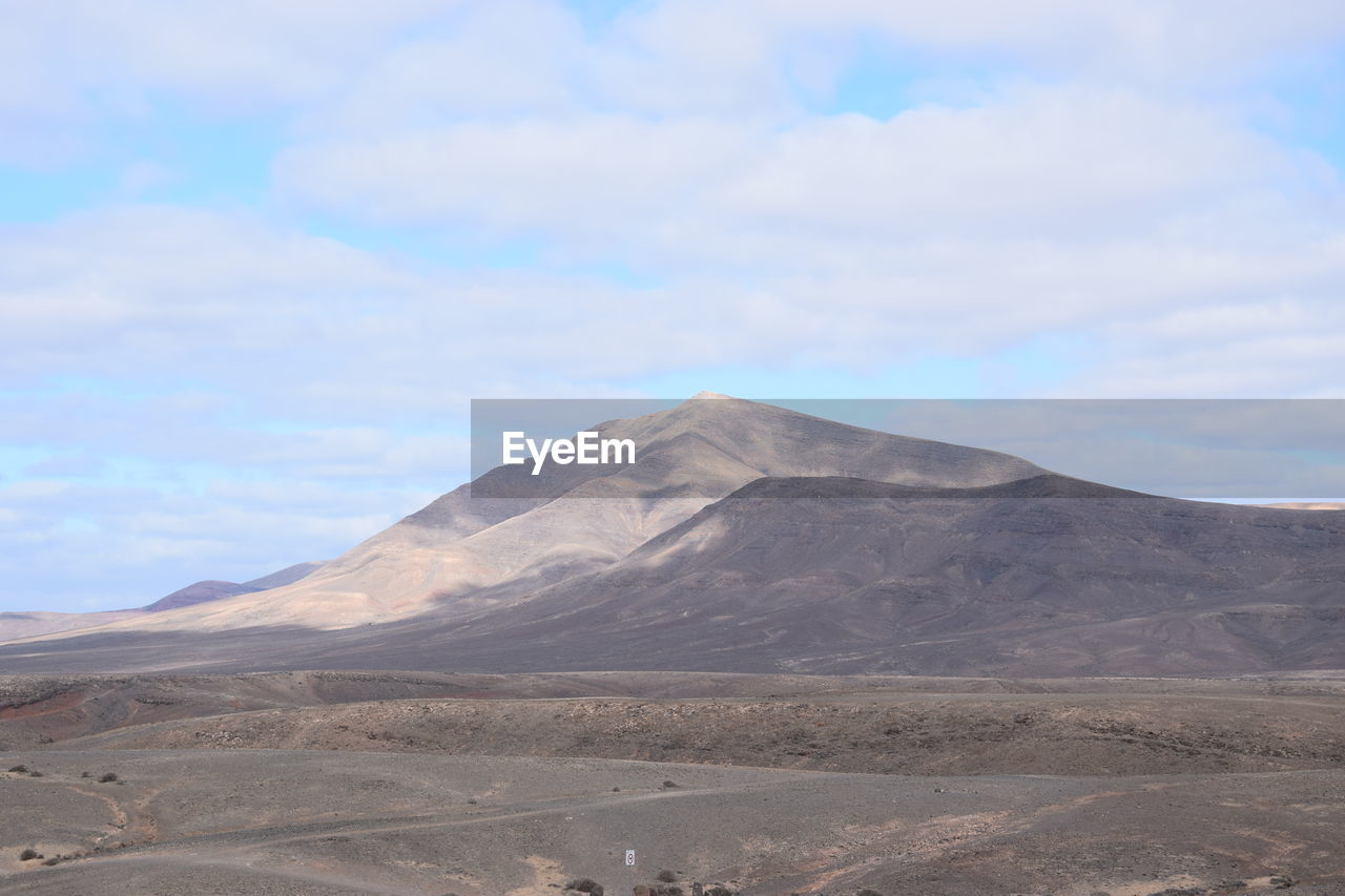 View of volcanic land against sky