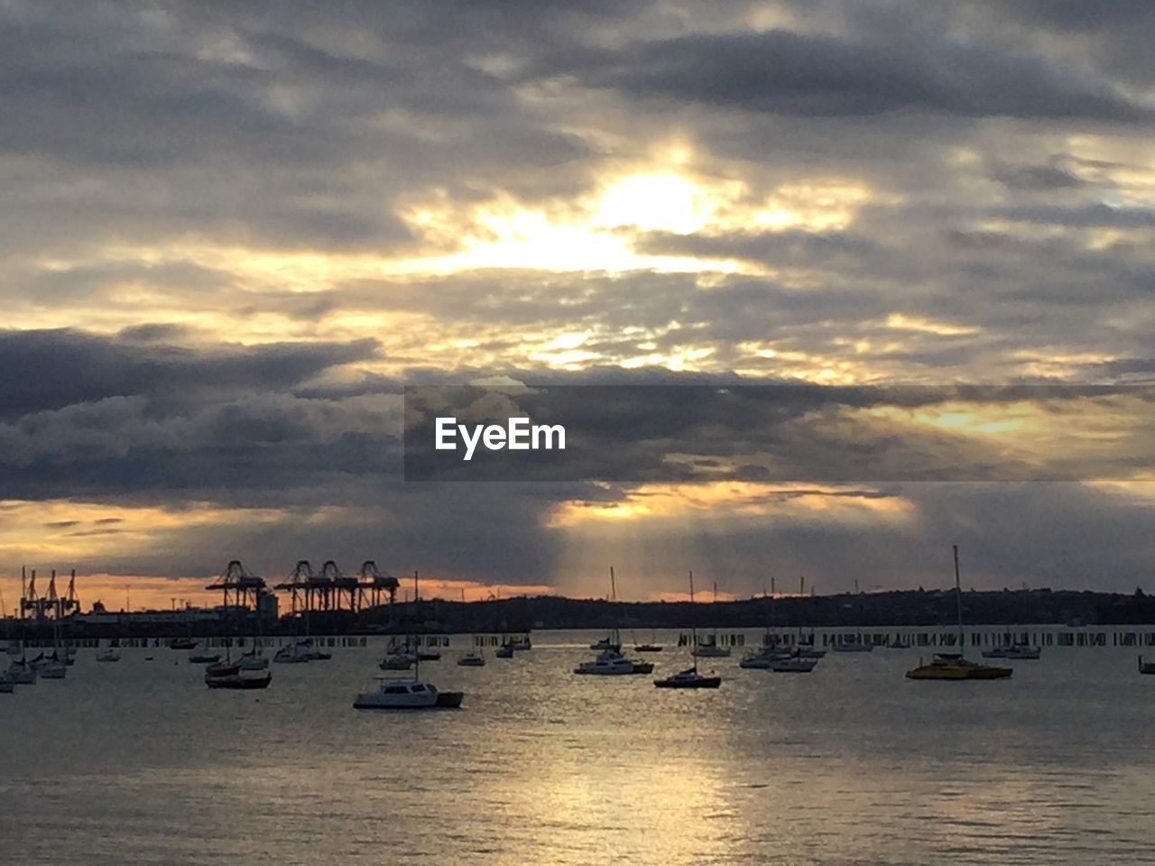 BOATS IN SEA AT SUNSET