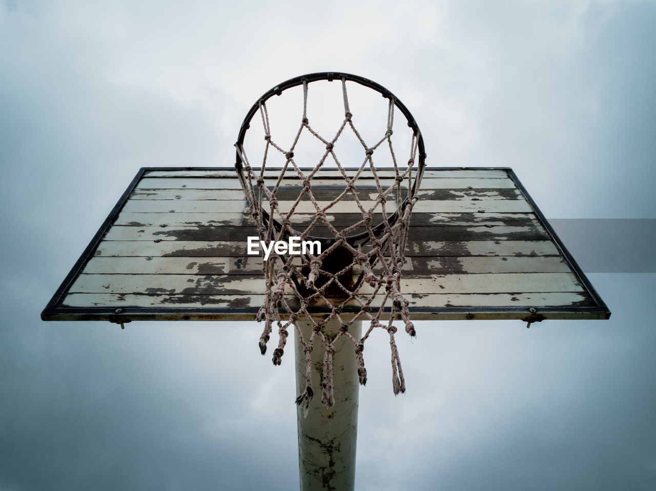 Low angle view of basketball hoop against cloudy sky