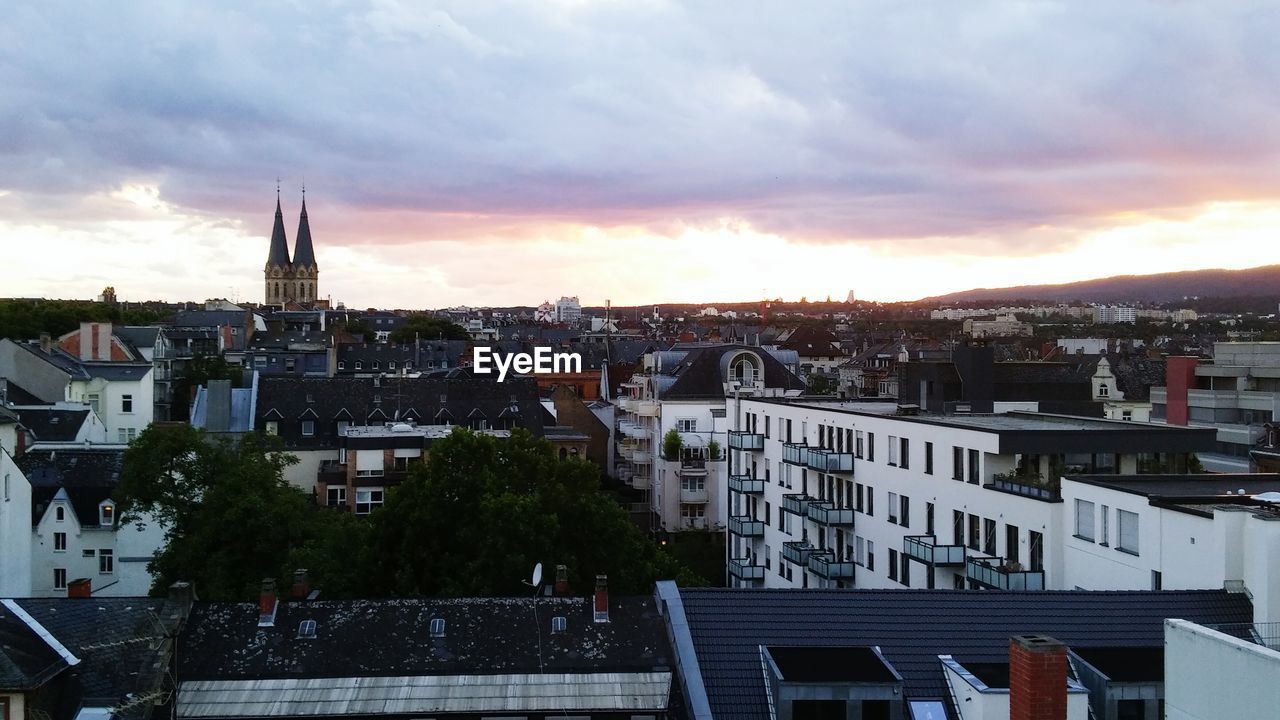 Buildings against cloudy sky at sunset