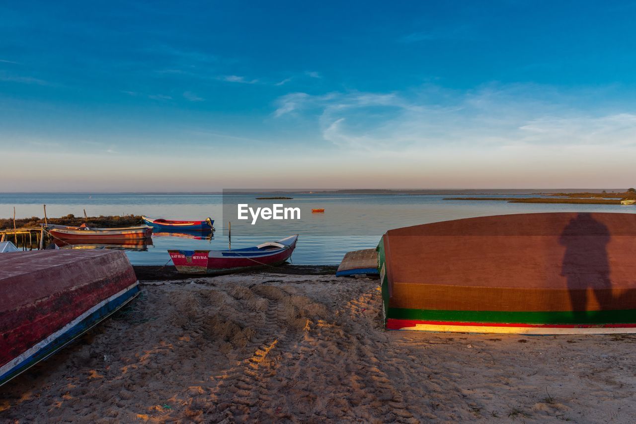 BOATS MOORED ON SEA AGAINST SKY