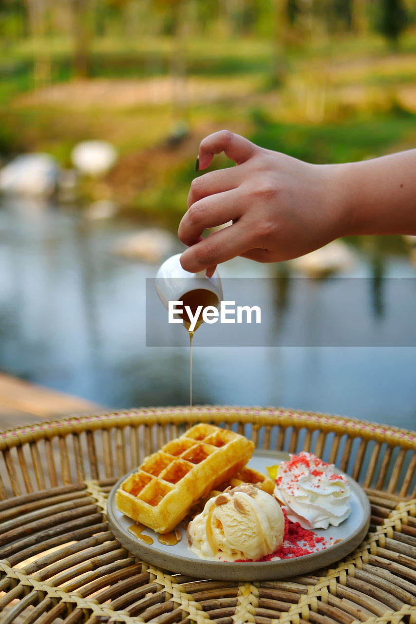 CLOSE-UP OF HAND HOLDING ICE CREAM CONE