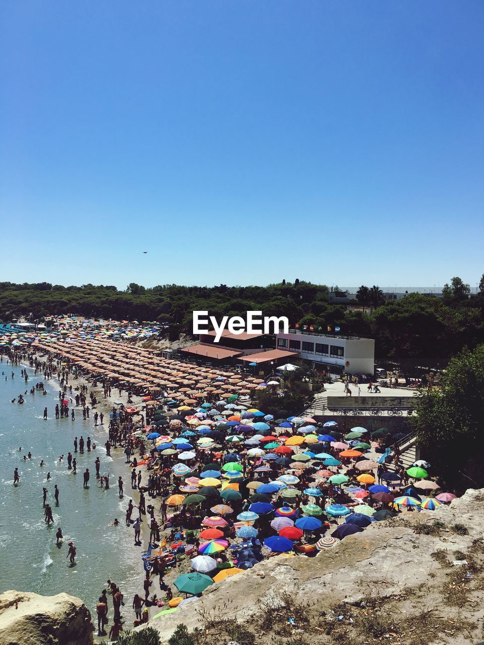 High angle view of people at beach against clear blue sky