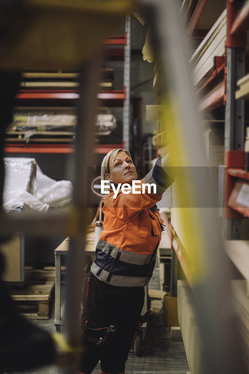 Mature female carpenter working in warehouse