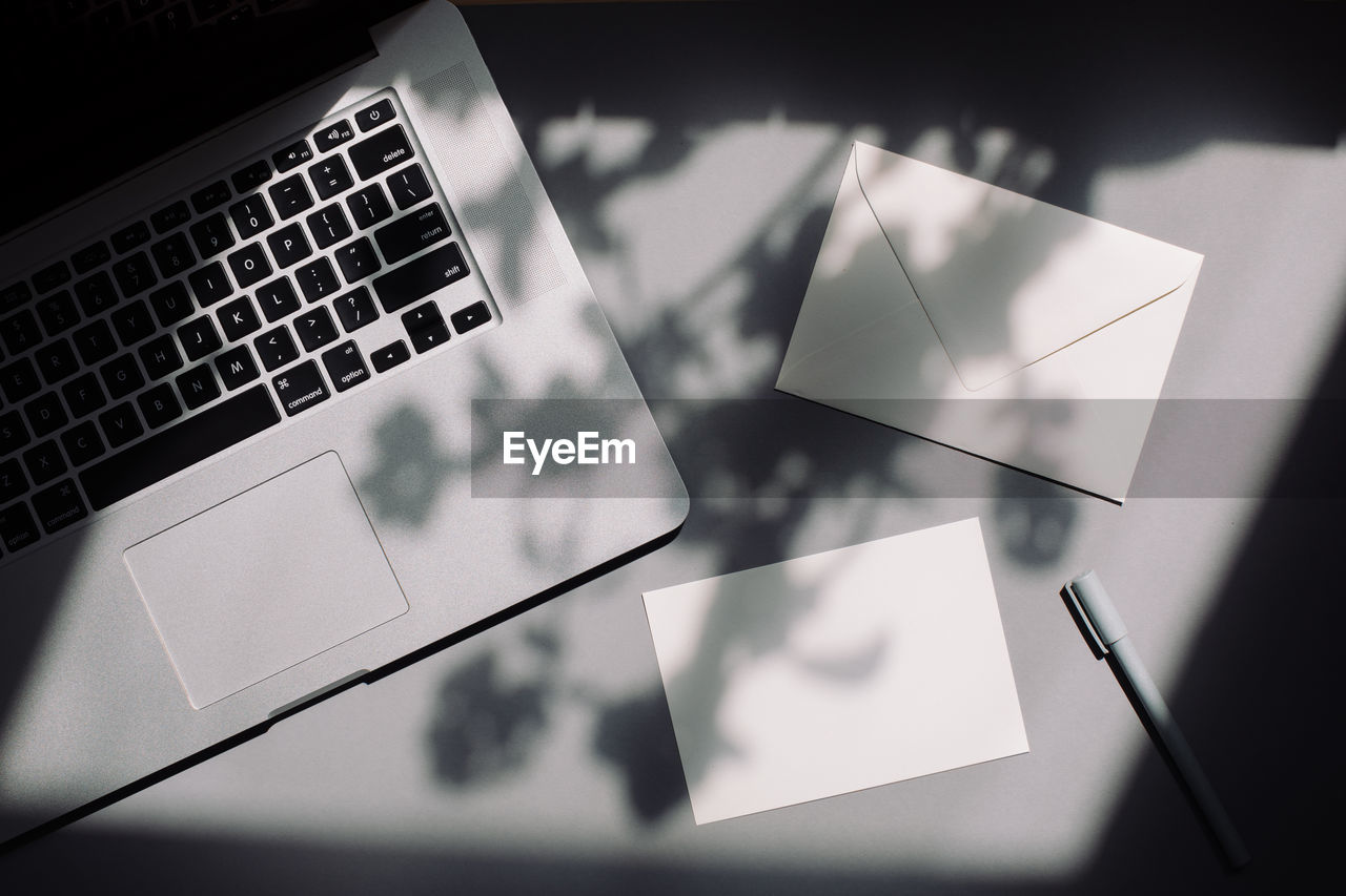 High angle view of laptop with envelope on table