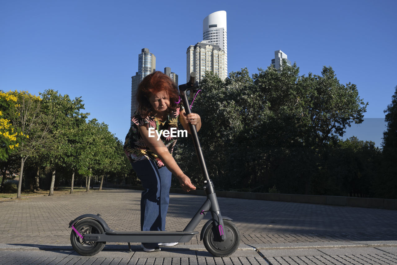 low angle view of woman standing on street against clear sky