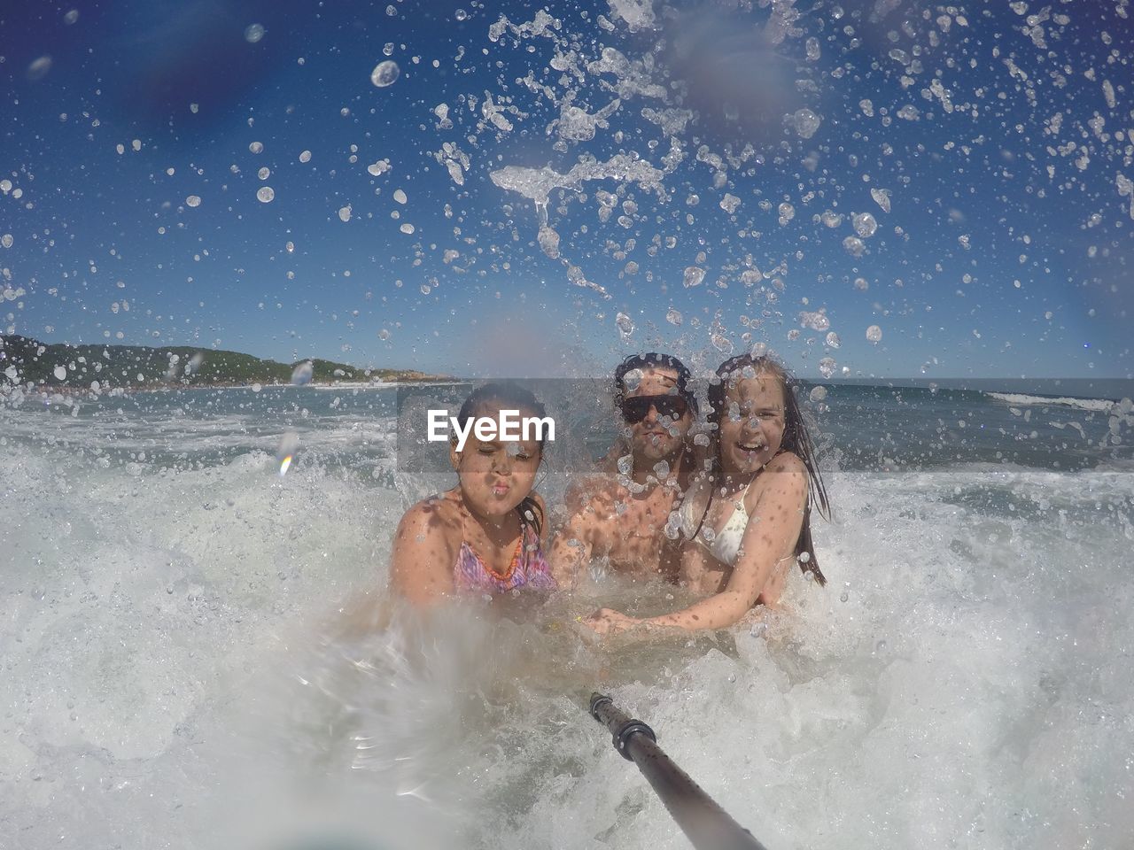 Family swimming in sea against sky