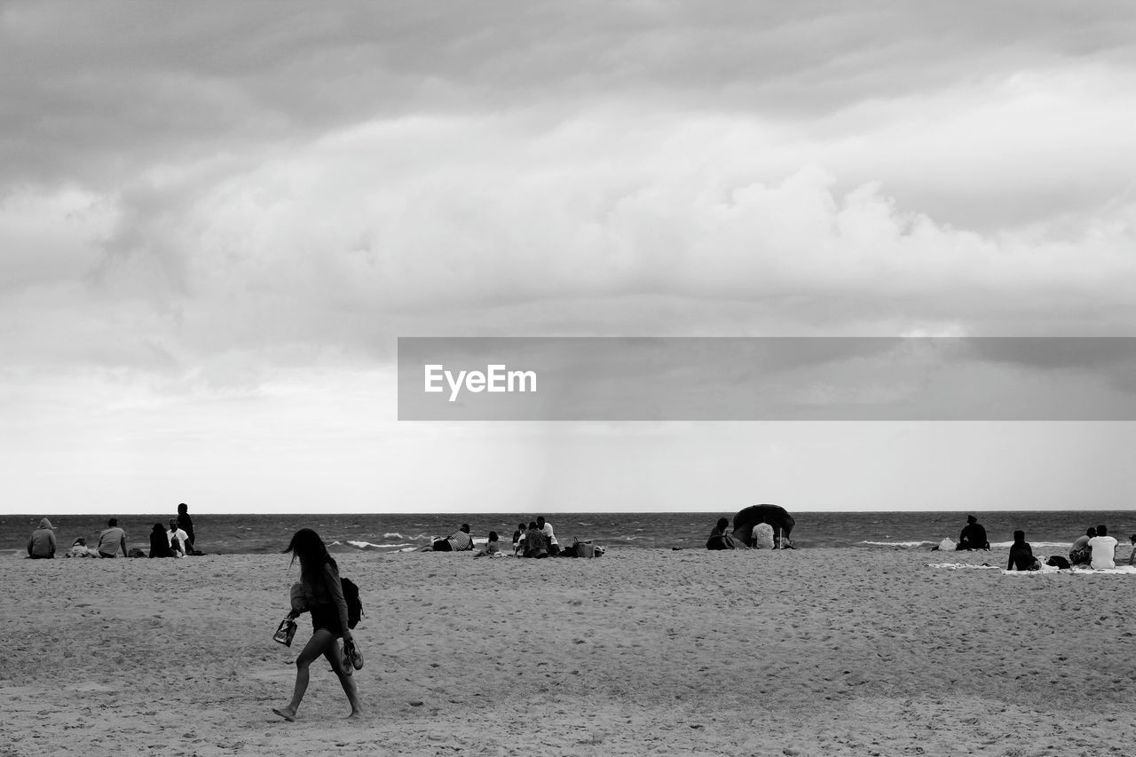 PEOPLE ENJOYING ON BEACH AGAINST SKY