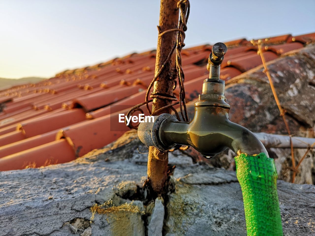 LOW ANGLE VIEW OF RUSTY METALLIC STRUCTURE AGAINST WALL