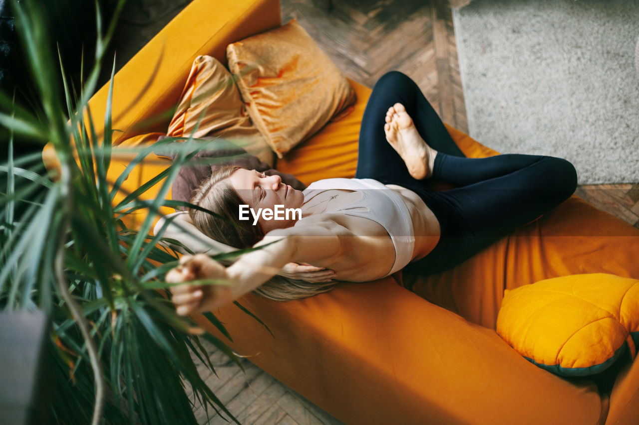 Top view of a young beautiful woman. the girl is sitting on the sofa in the lotus position 