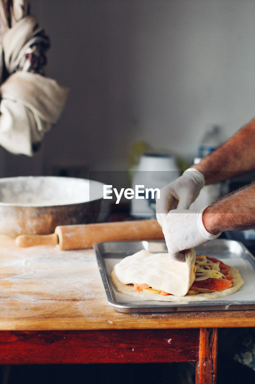 Cropped hands of man preparing food in kitchen