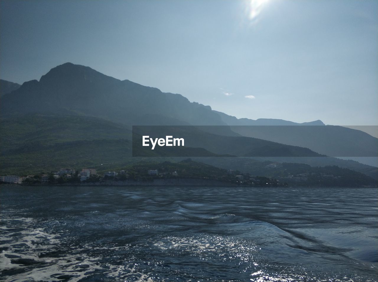 SCENIC VIEW OF SEA AGAINST MOUNTAINS