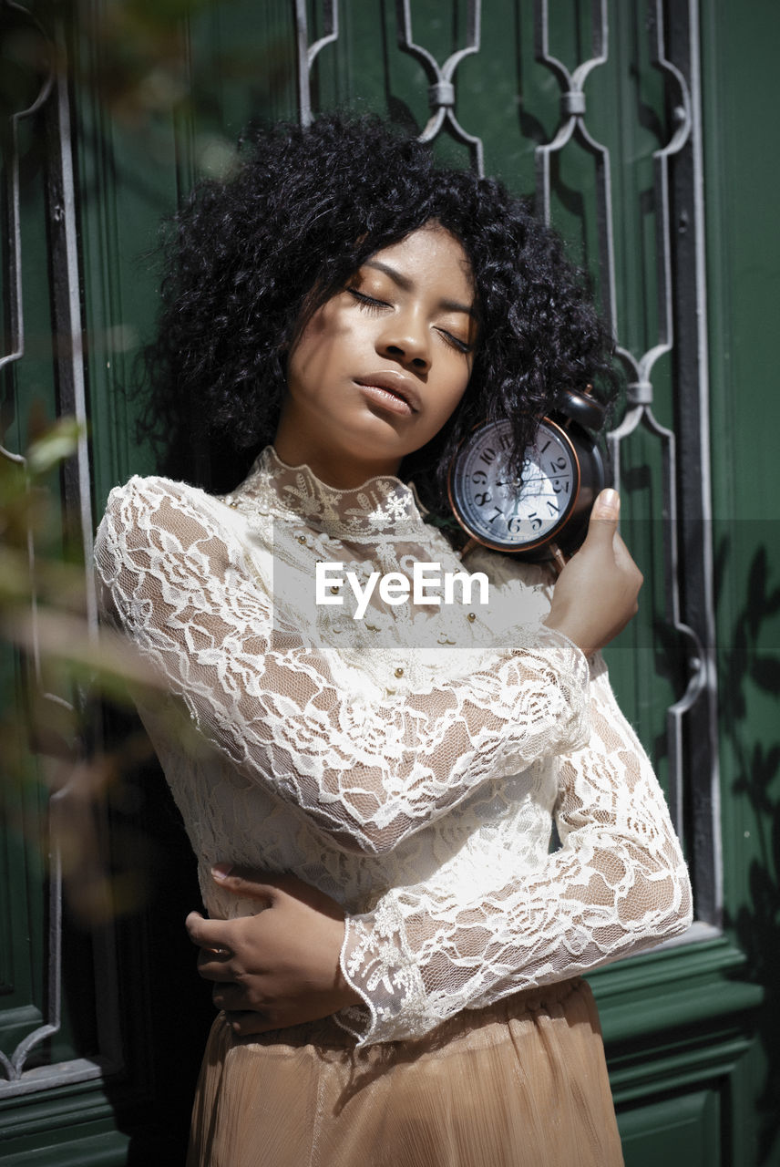 Portrait of a woman by the door with a clock