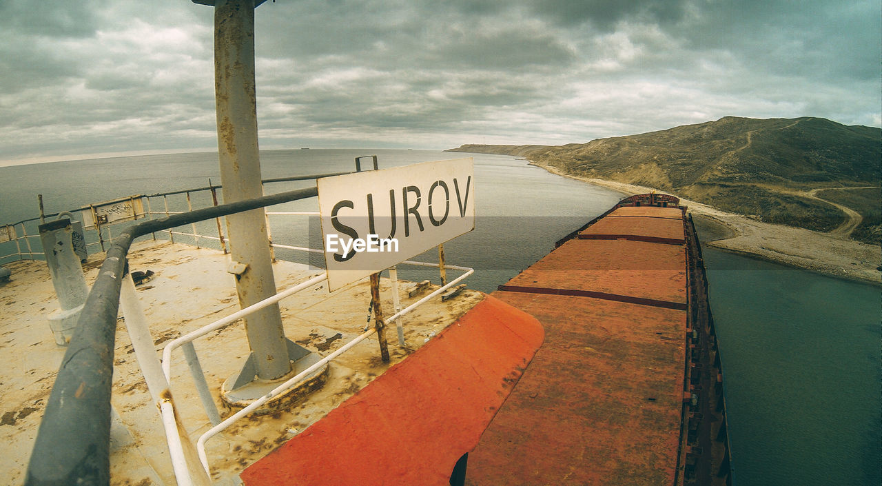 TEXT ON RAILING AGAINST SEA