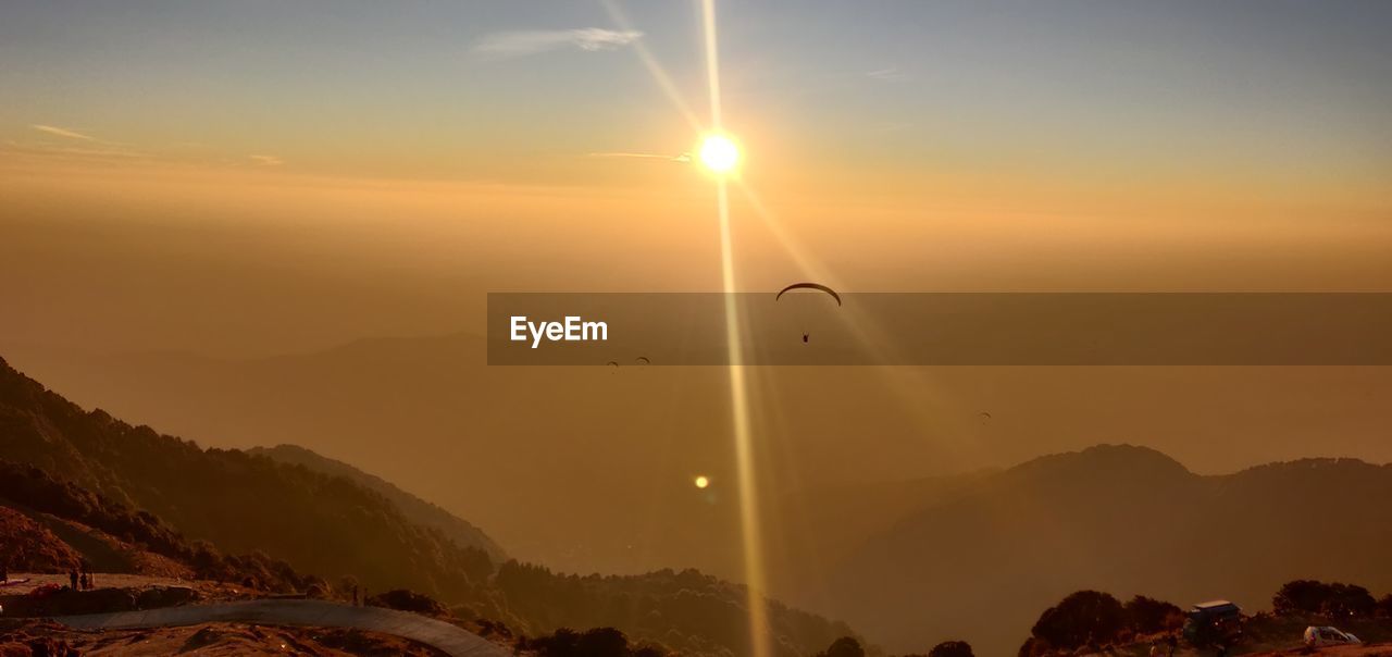 SCENIC VIEW OF MOUNTAINS AGAINST ORANGE SKY