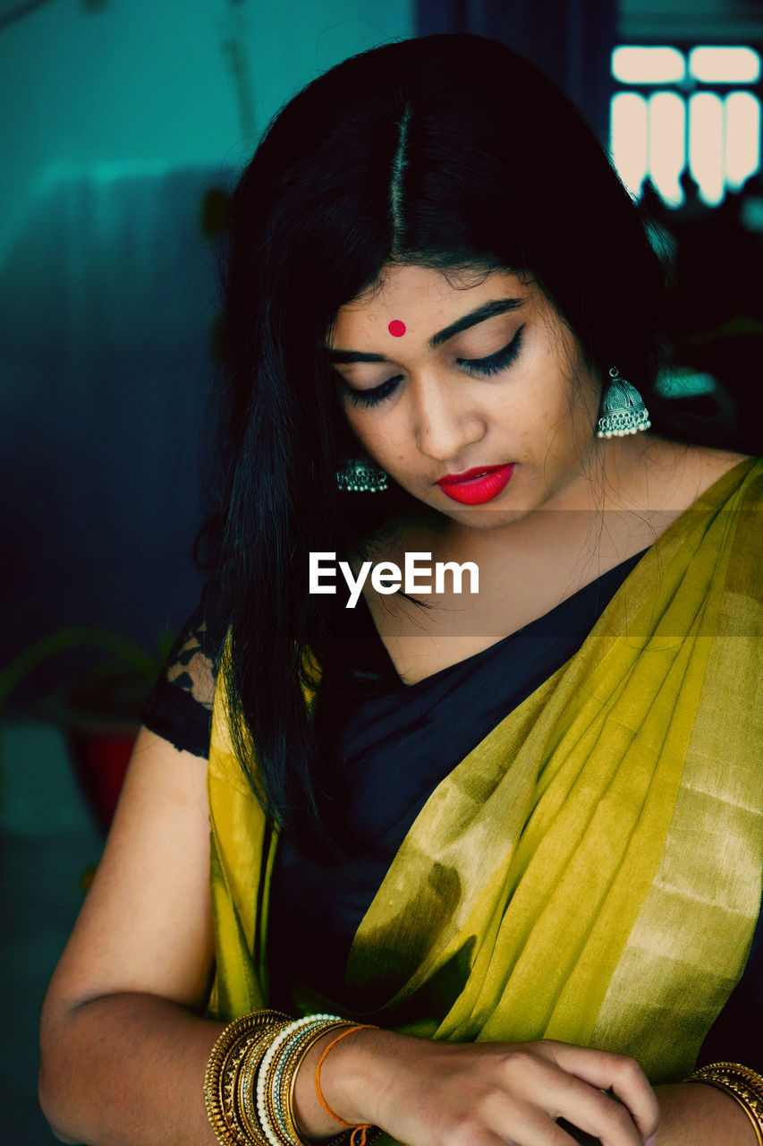 Woman wearing sari standing at home