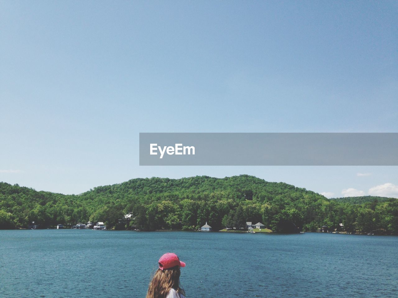 Woman by lake against sky