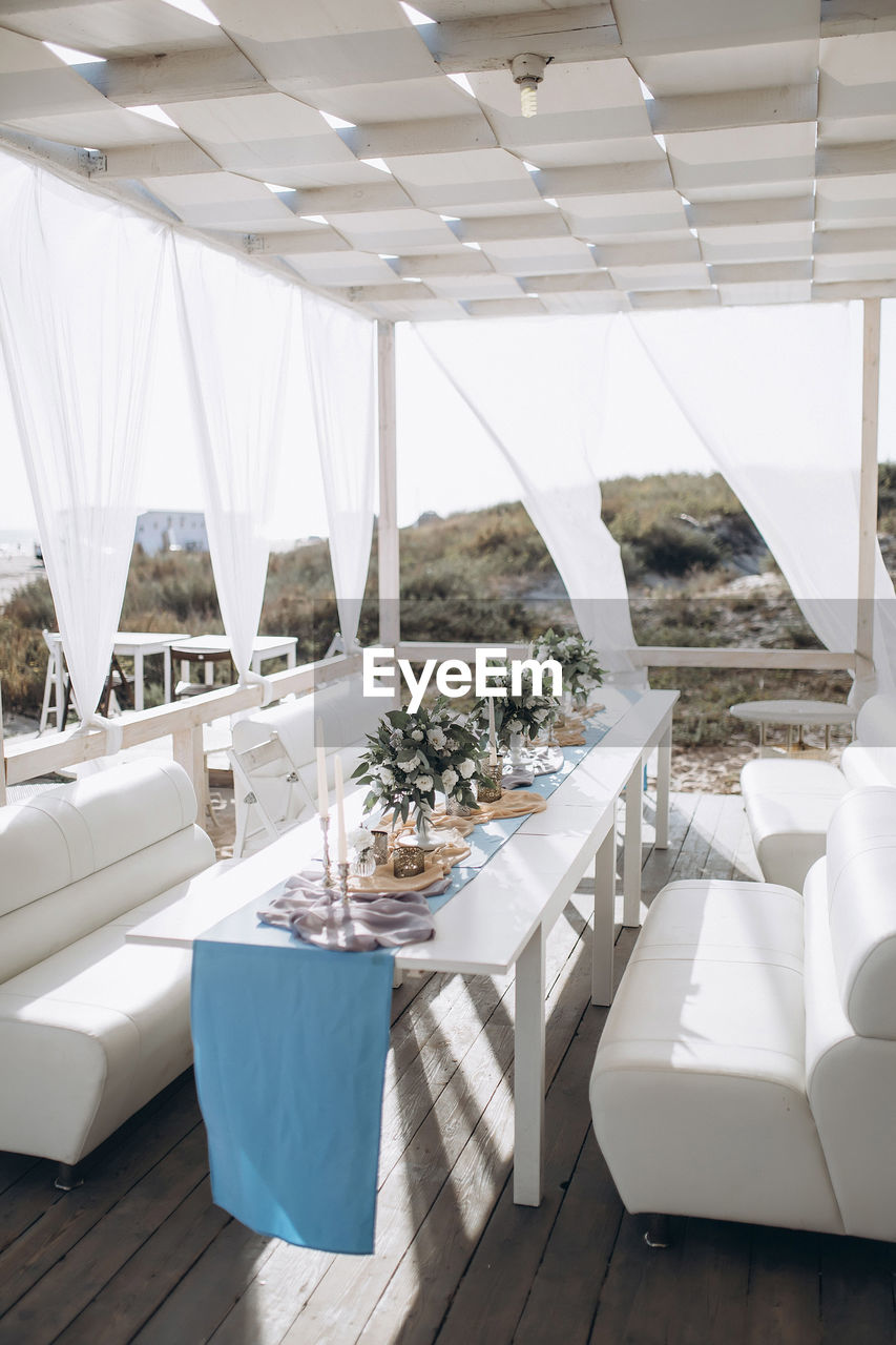 Restaurant hall on the sea coast, decorated with paper lamps and white fabrics