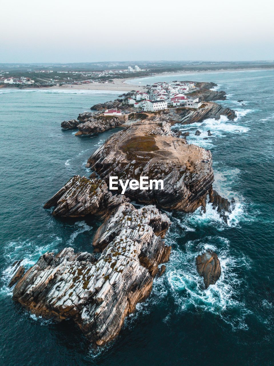 Aerial view of rocks in sea against sky