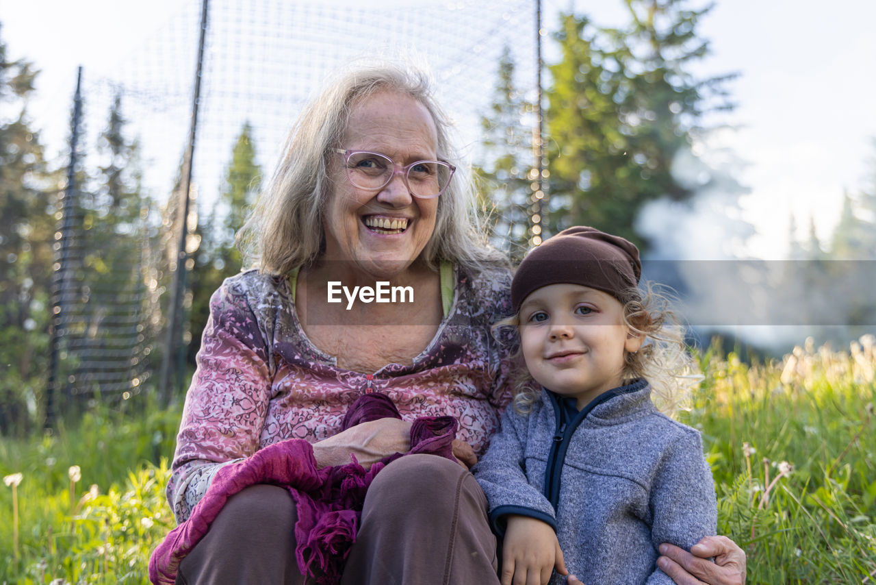 Grandmother sitting with grandson in garden