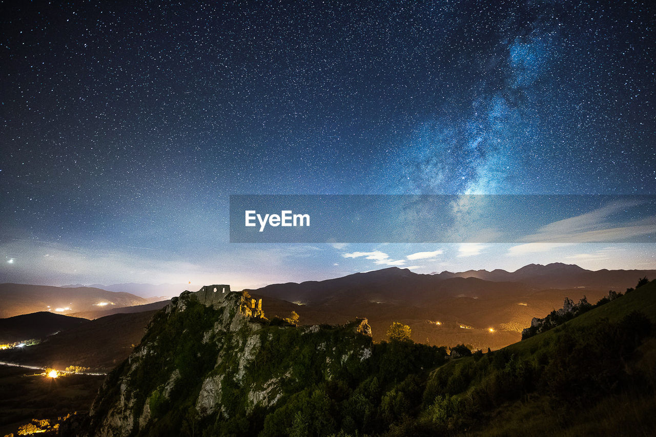 Scenic view of mountains against sky at night