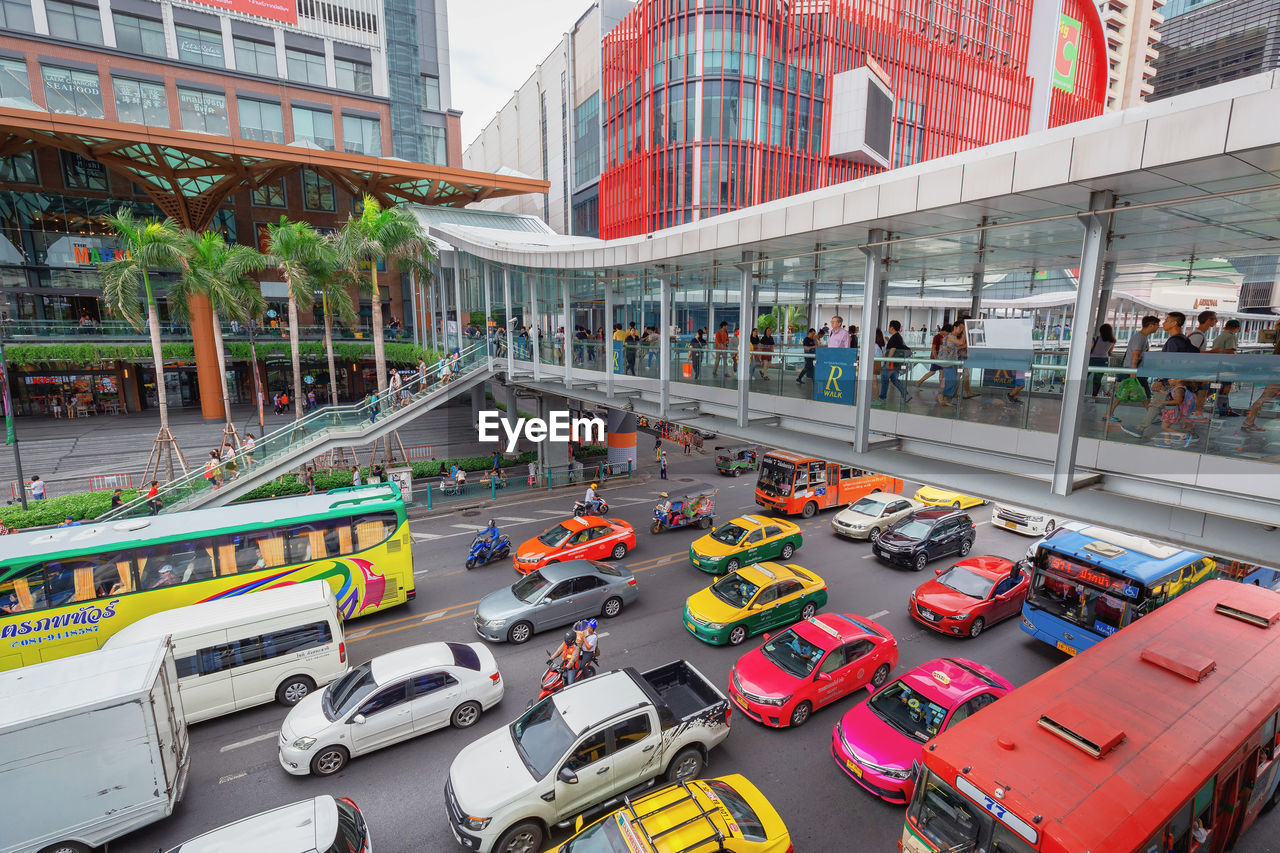 HIGH ANGLE VIEW OF TRAFFIC ON ROAD AMIDST BUILDINGS