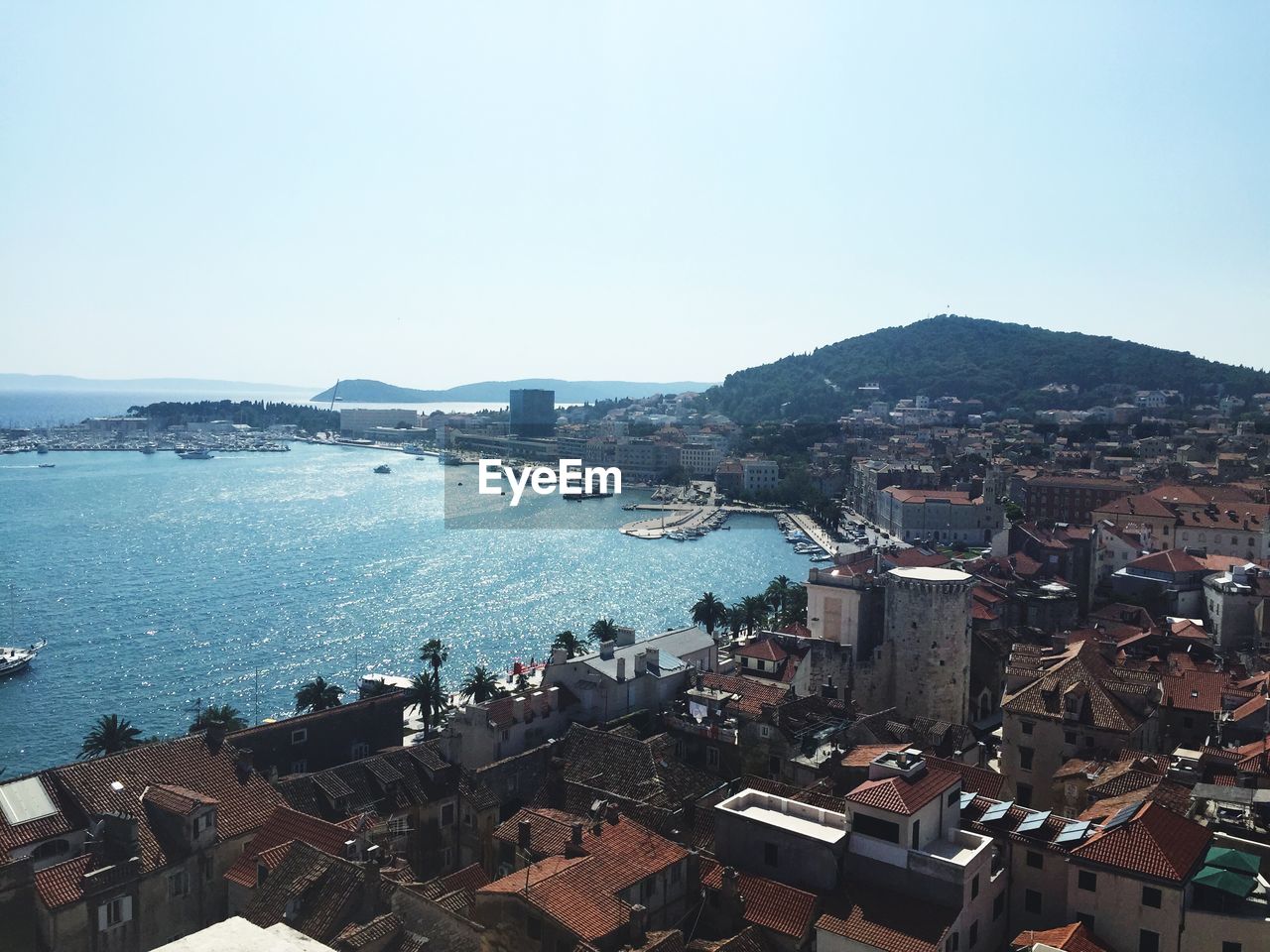 High angle view of sea and cityscape against sky