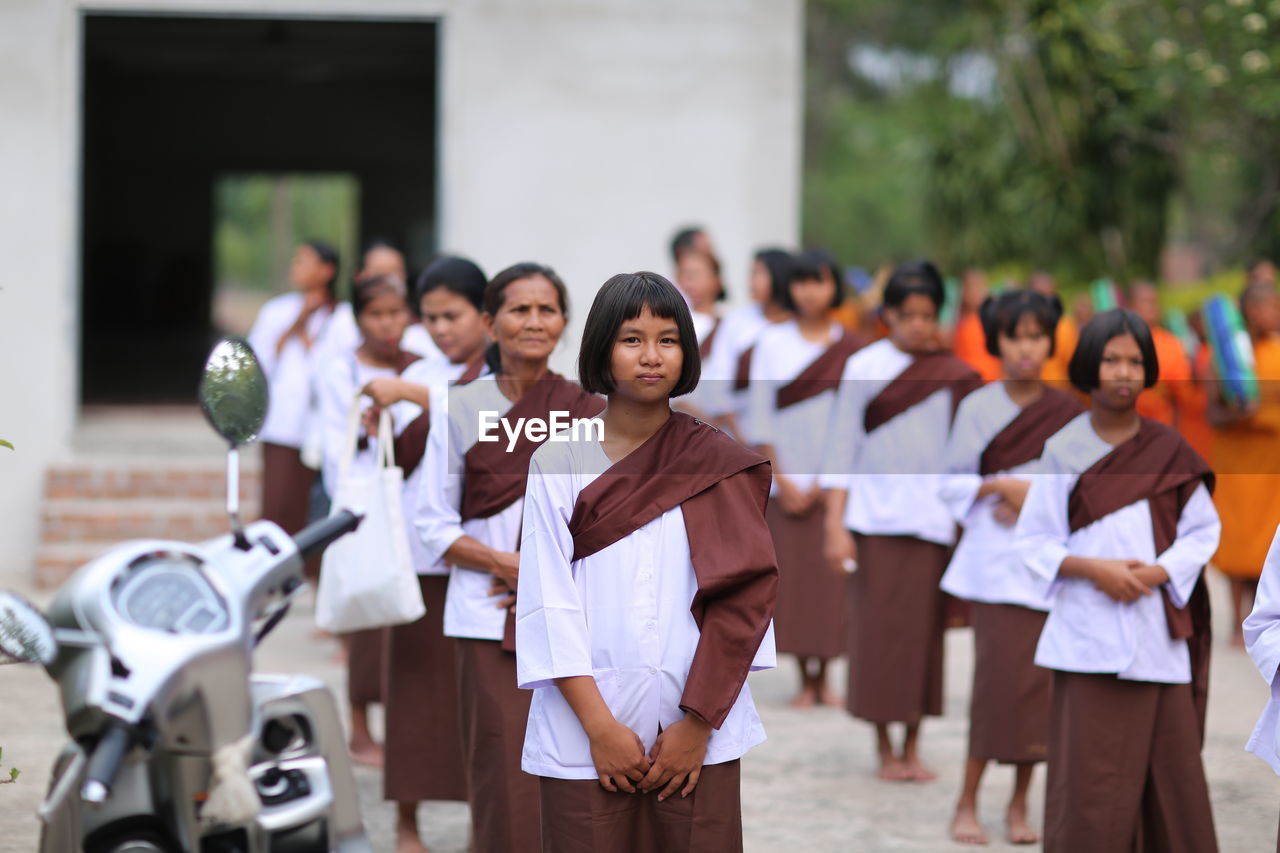 HIGH ANGLE VIEW OF PEOPLE STANDING AGAINST BLURRED BACKGROUND