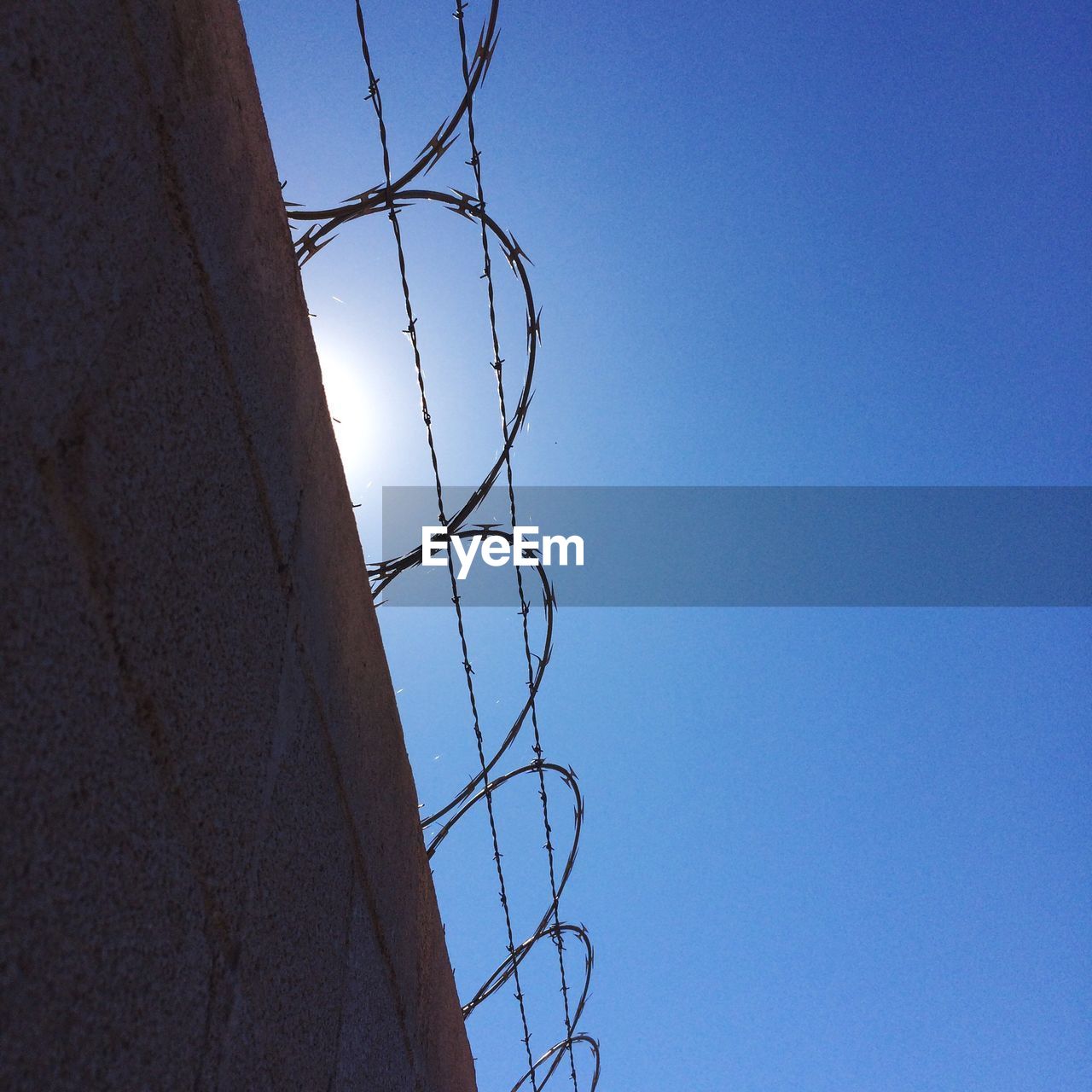 Low angle view of razor wire against clear sky