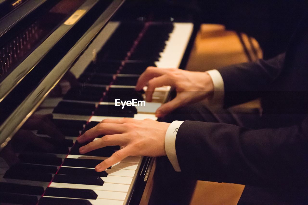 Midsection of man playing piano