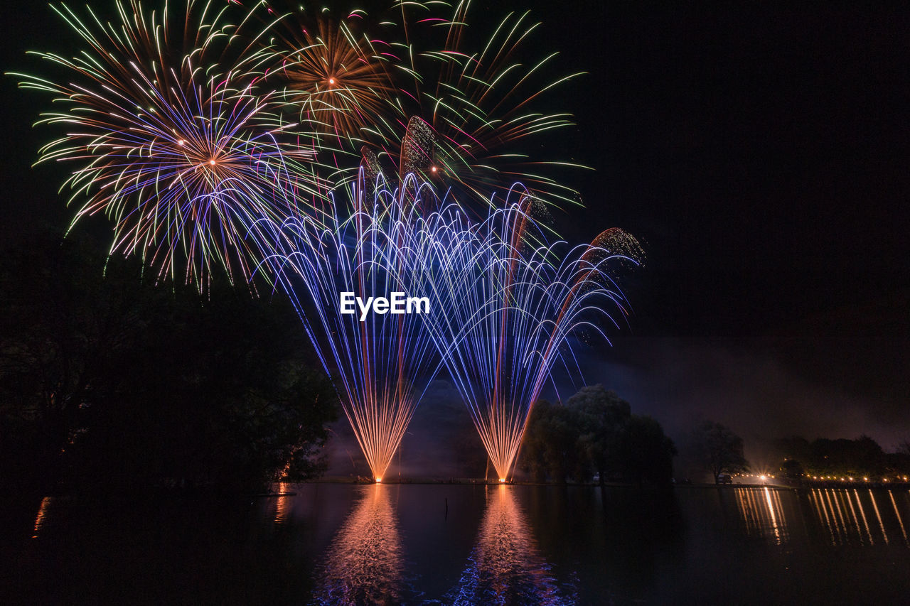 LOW ANGLE VIEW OF FIREWORKS DISPLAY AT NIGHT