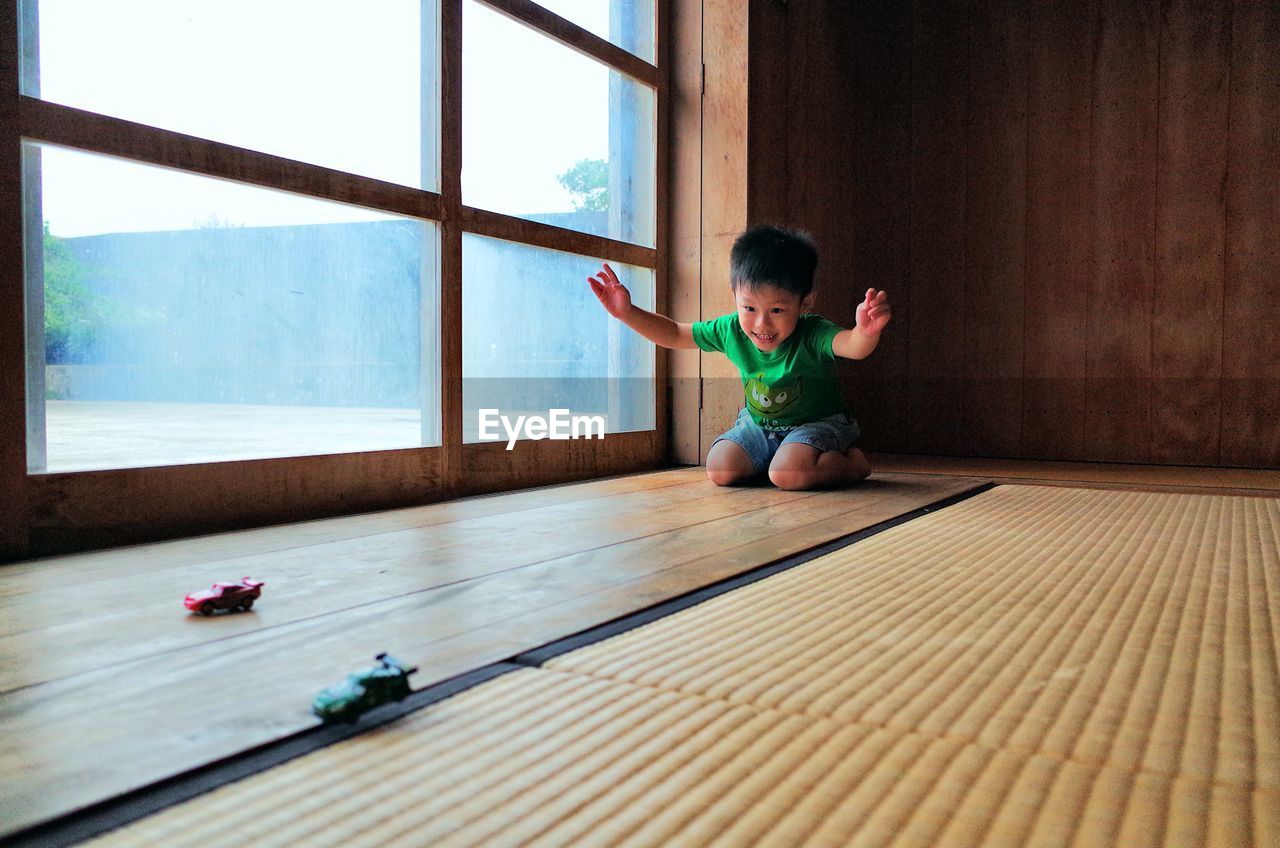 Cute boy playing with toy cars at home