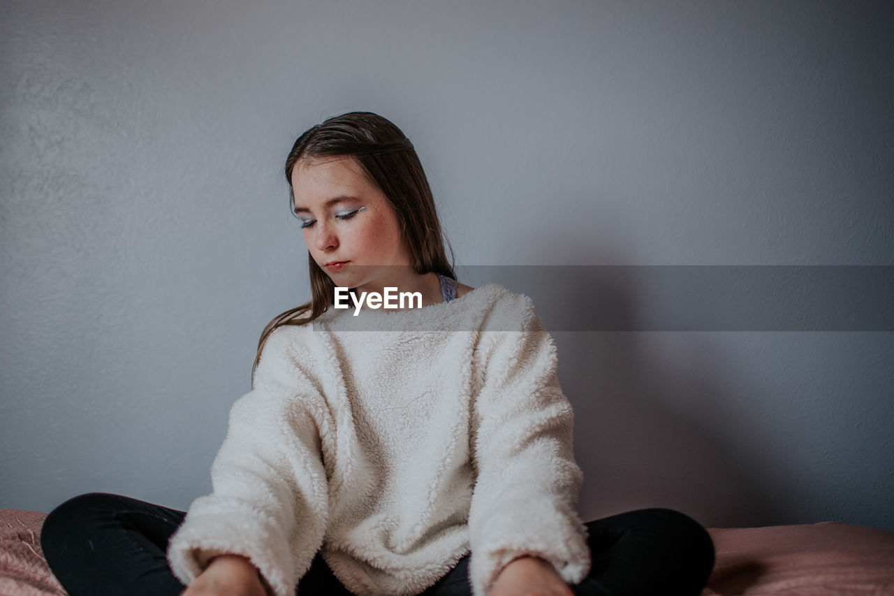 Horizontal portrait of tween girl sitting and looking down